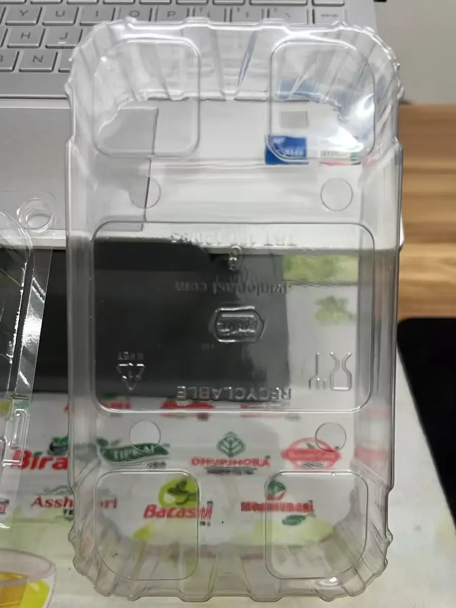 Clear thermoformed plastic tray, top view showing corner and centre cavities